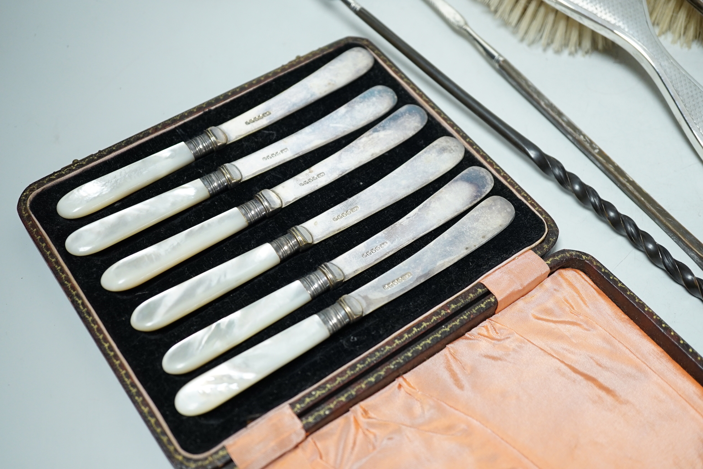 A George V silver mounted five piece dressing table set, two Georgian silver punch ladles and cased tea knives.
